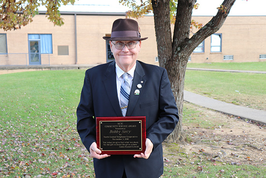 Bobby Sircy holding community service award
