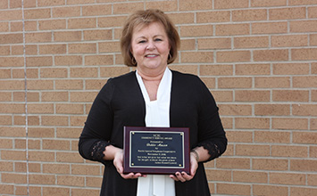 Debbie Mason holding the community service award