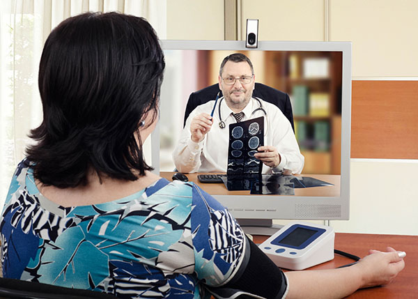 Woman on telehealth video call with doctor